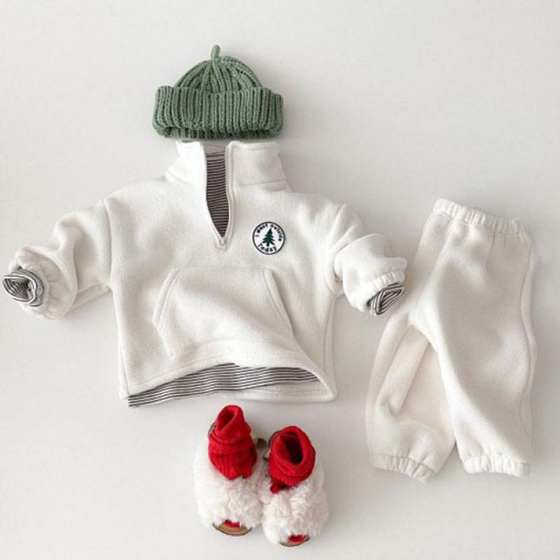 White fleece half-zip baby set with green beanie and red slippers