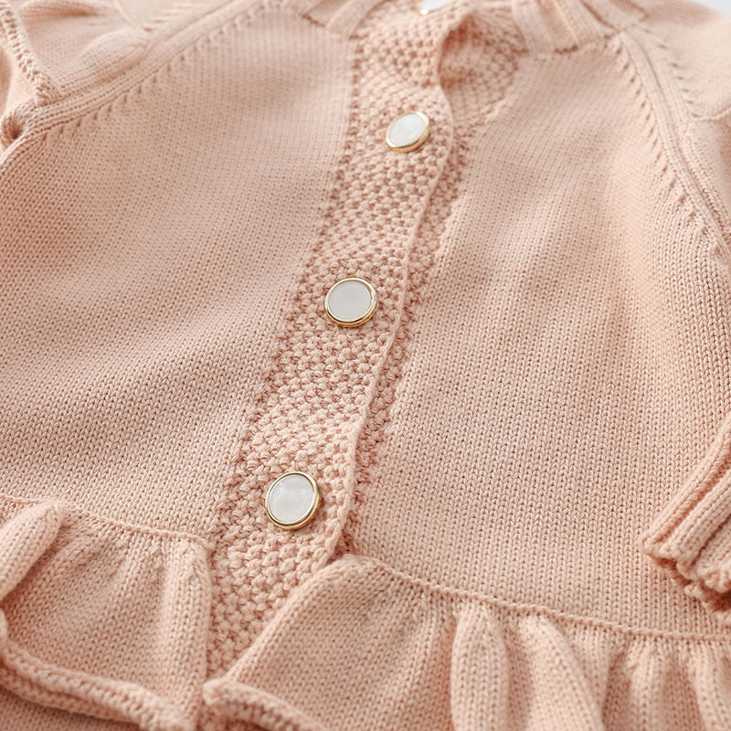 Button front and ruffle waist detail on pink knit jumpsuit