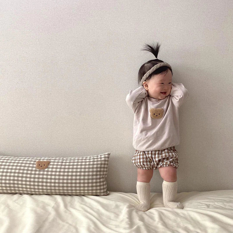 Baby standing in bear patch sweatshirt