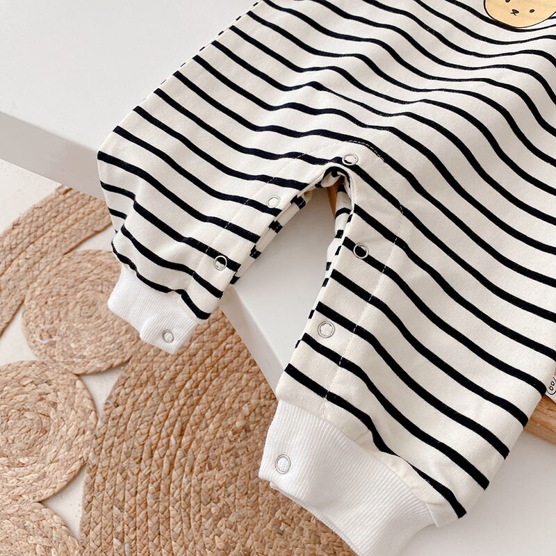 Leg snap closures on black and white striped baby jumpsuit