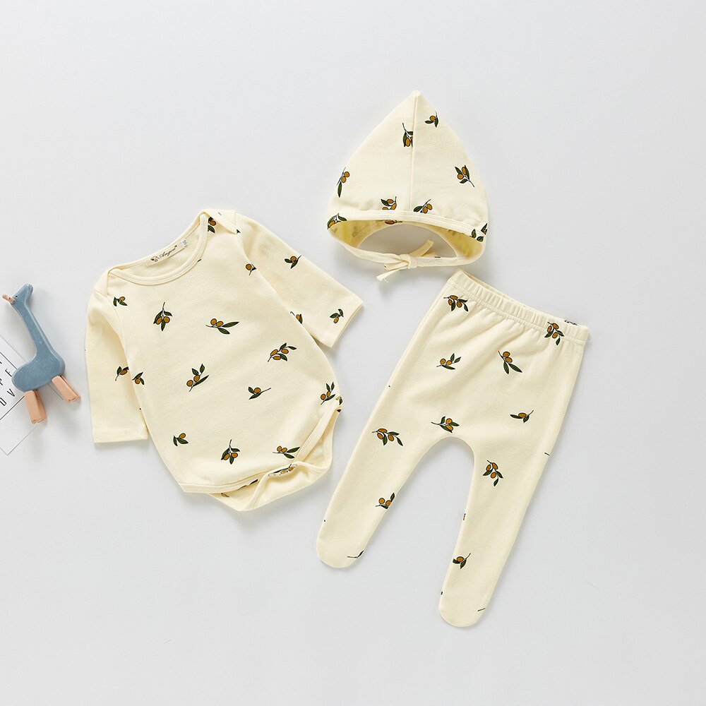 Cream printed baby romper, pants and pointed hat flat lay