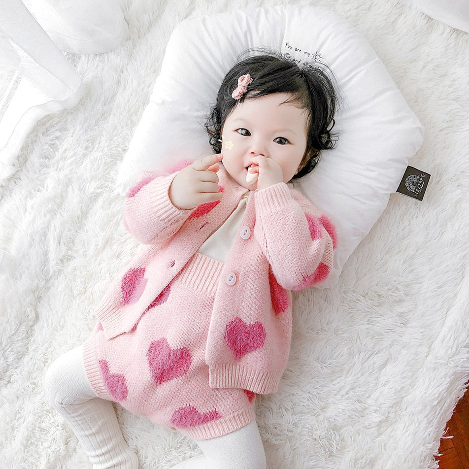 Baby wearing pink heart knit cardigan