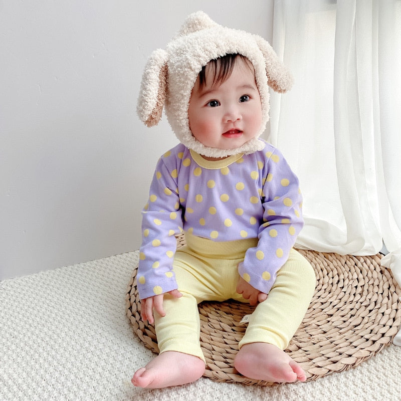 Baby wearing purple polka dot set with bear hat