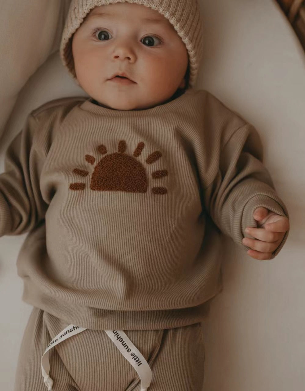 Baby wearing a khaki sun sweatshirt and joggers