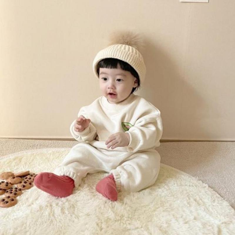 Baby wearing white rainbow sweatshirt set