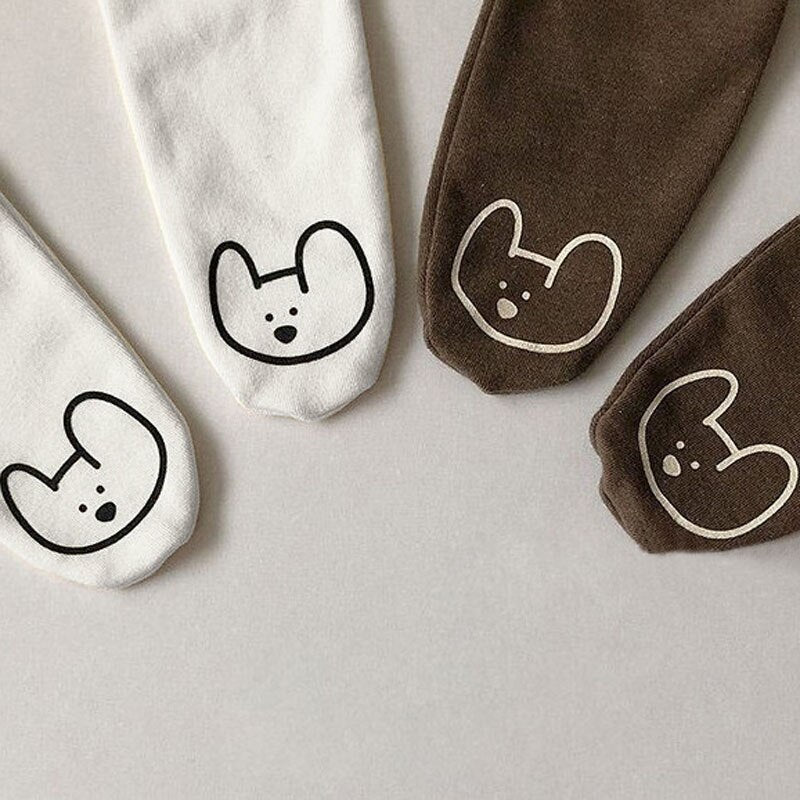 Close-up of embroidered bear faces on feet