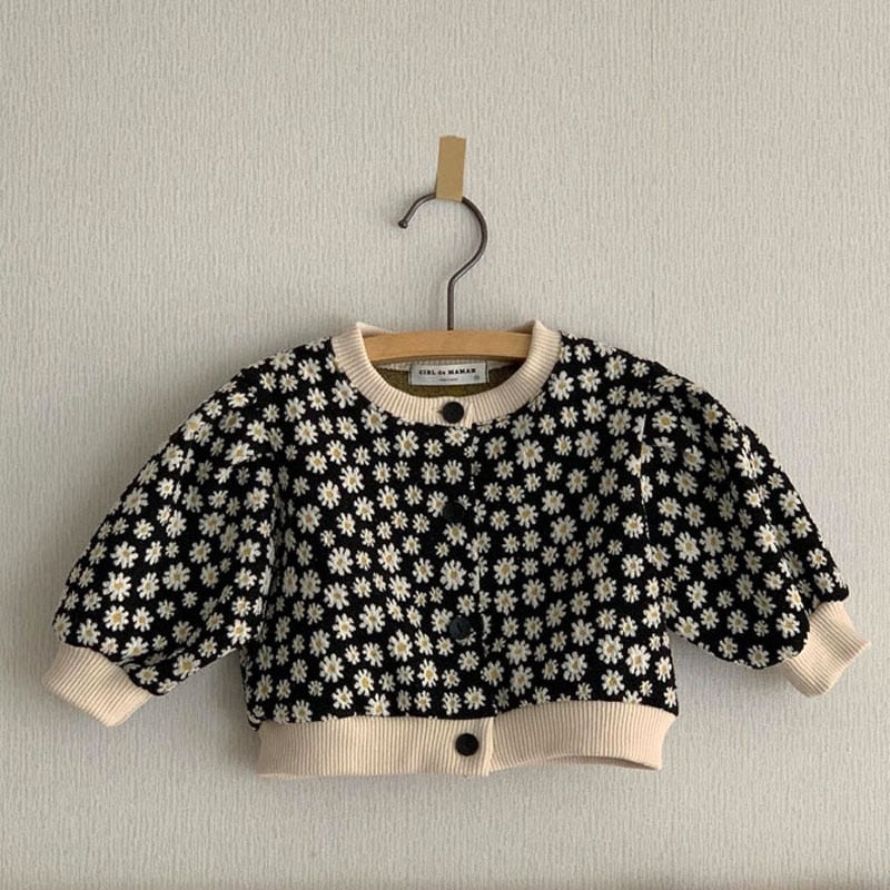 Black daisy knit cardigan on a hanger