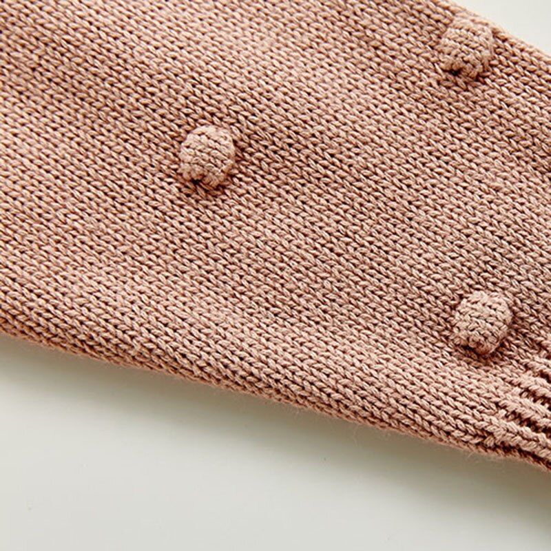 Close-up of bobbles on pink knit sleeve