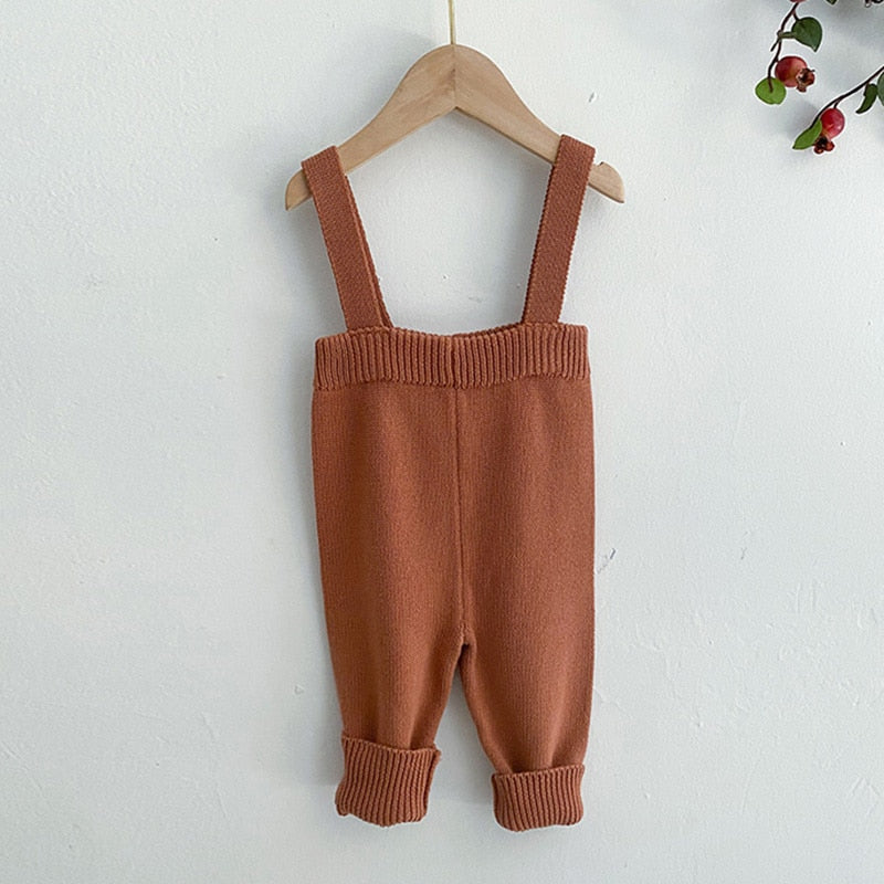 Brown knitted suspender overalls on a hanger