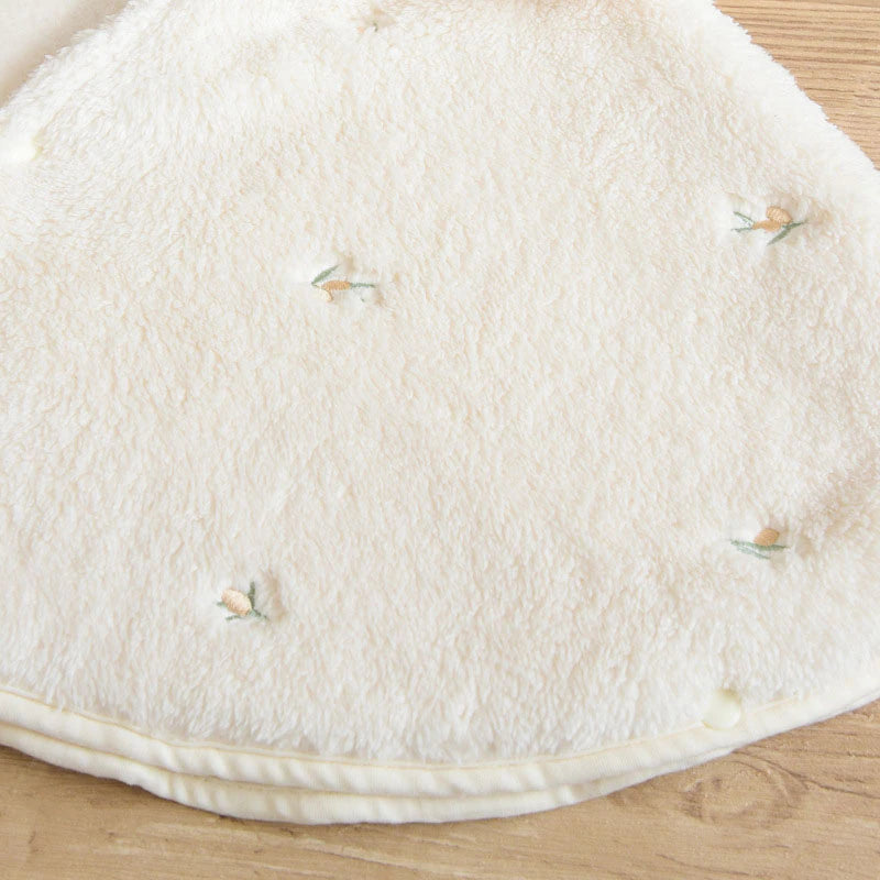Close-up of tiny embroidery on plush cape
