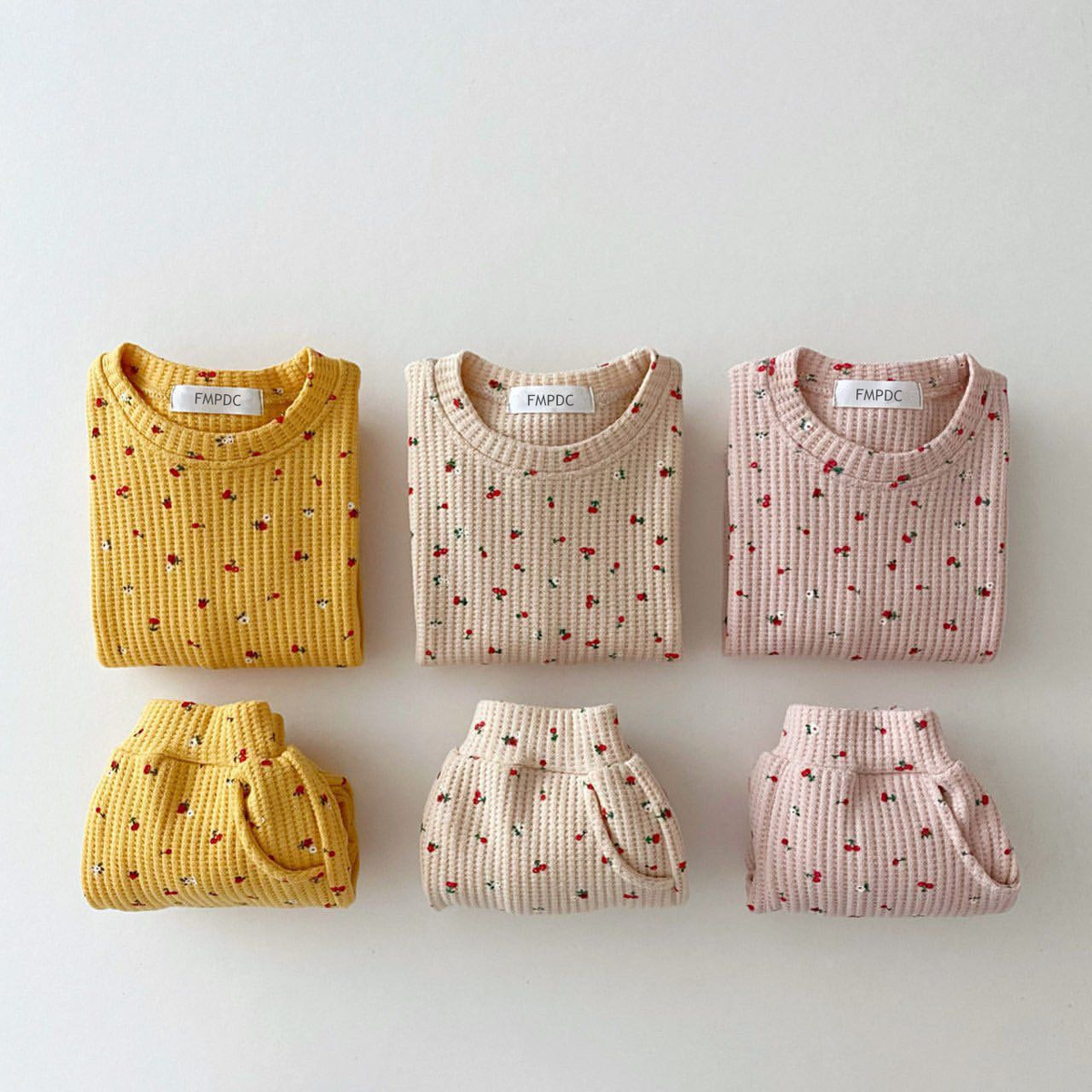 Yellow, white and pink cherry print sets laid flat