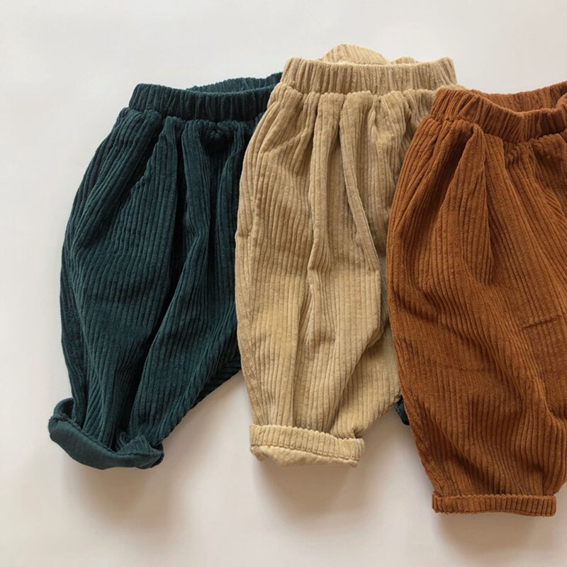Green, beige and brown corduroy pants laid flat