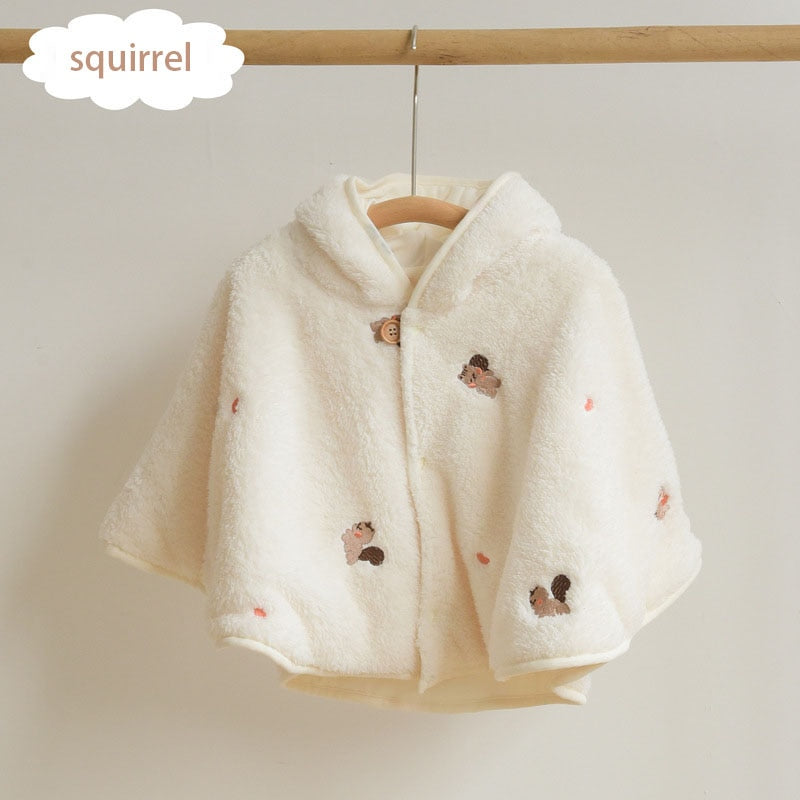 Cream cape with bear embroidery on a hanger