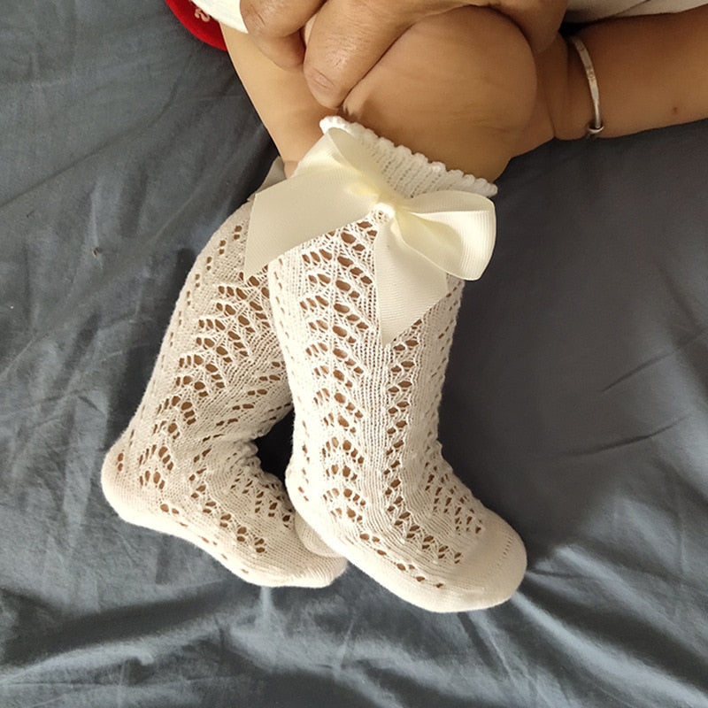 Baby wearing cream openwork bow socks