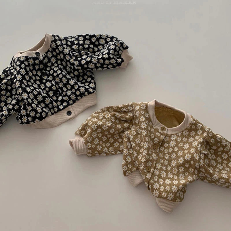 Pair of daisy knit cardigans laid flat