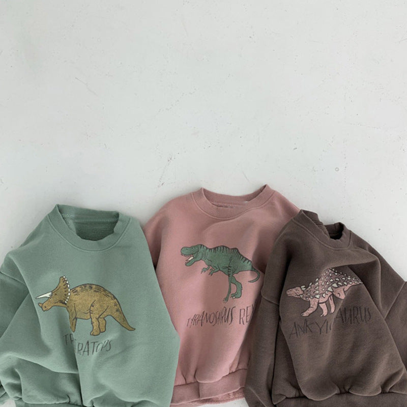 Close-up of green, pink and brown dinosaur bodysuits