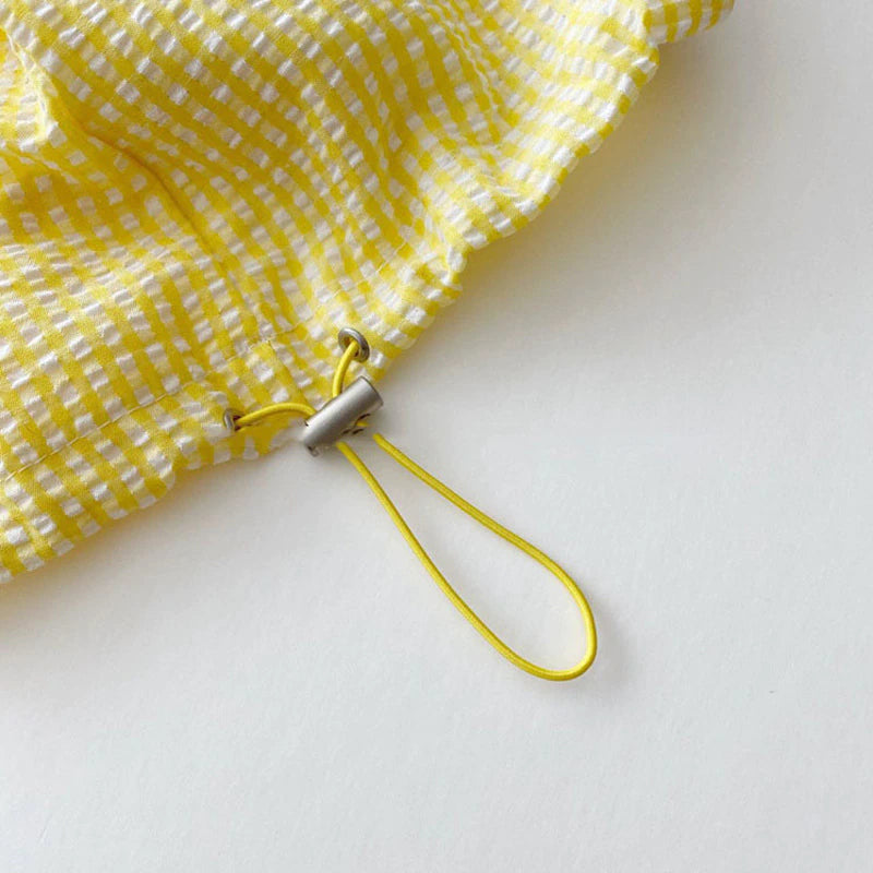 Close-up of drawstring hem toggle on yellow jacket
