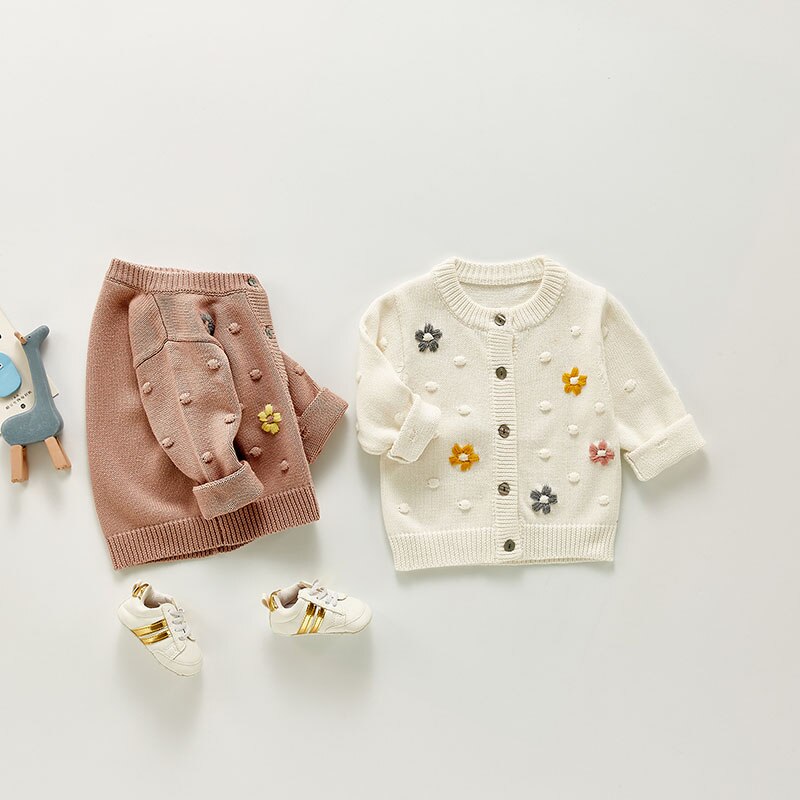 Floral embroidered cardigans laid flat with socks