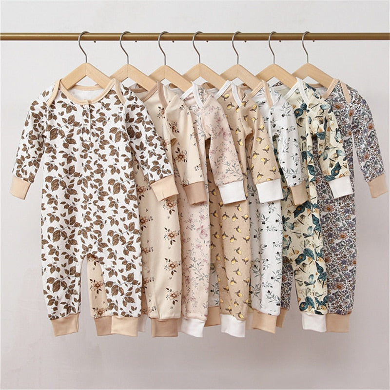 Eight floral print baby rompers hanging on a rail