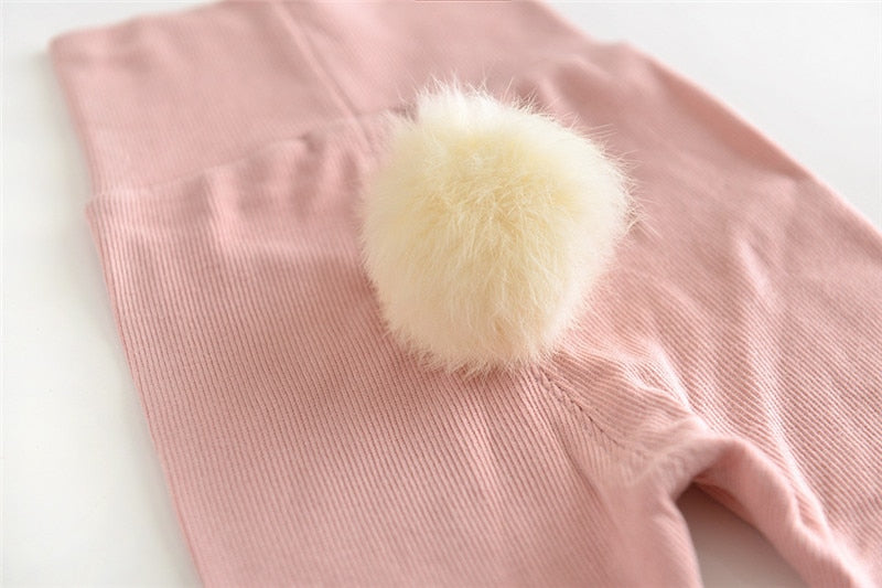 Close-up of fluffy bunny tail on pink leggings