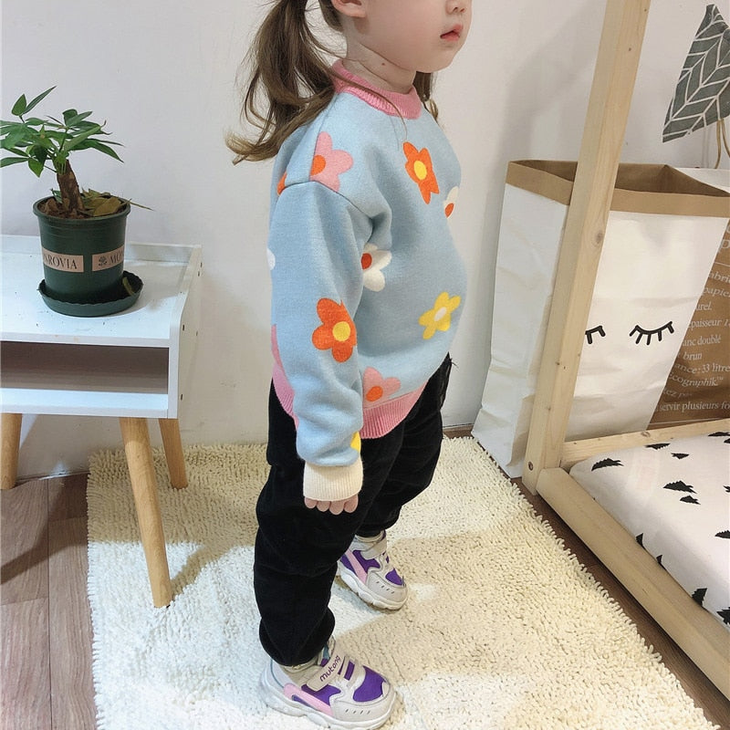 Girl wearing blue daisy knit sweater
