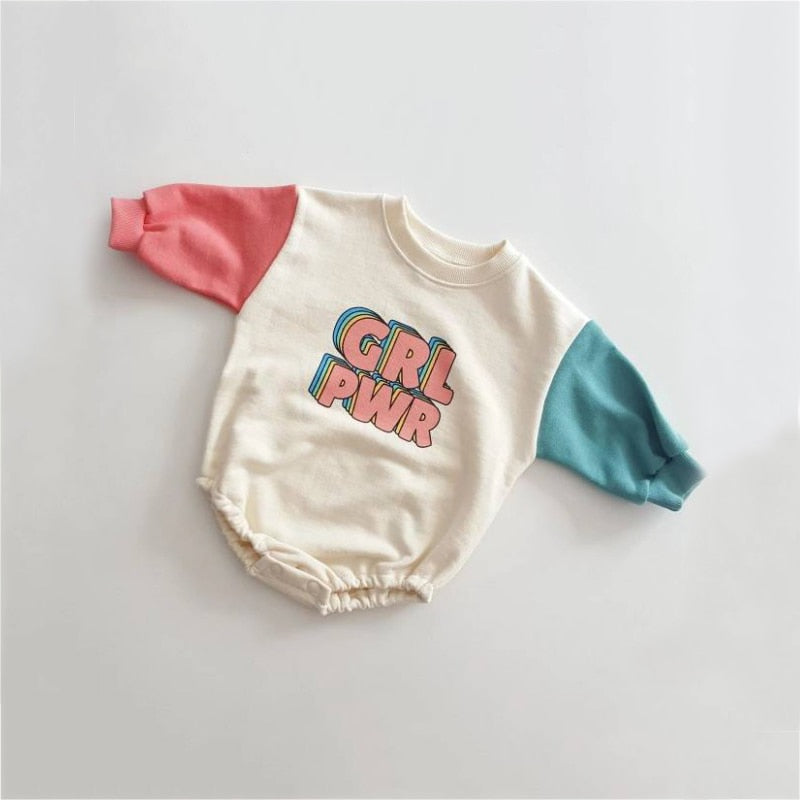 Cream GRL PWR romper with pink and teal sleeves