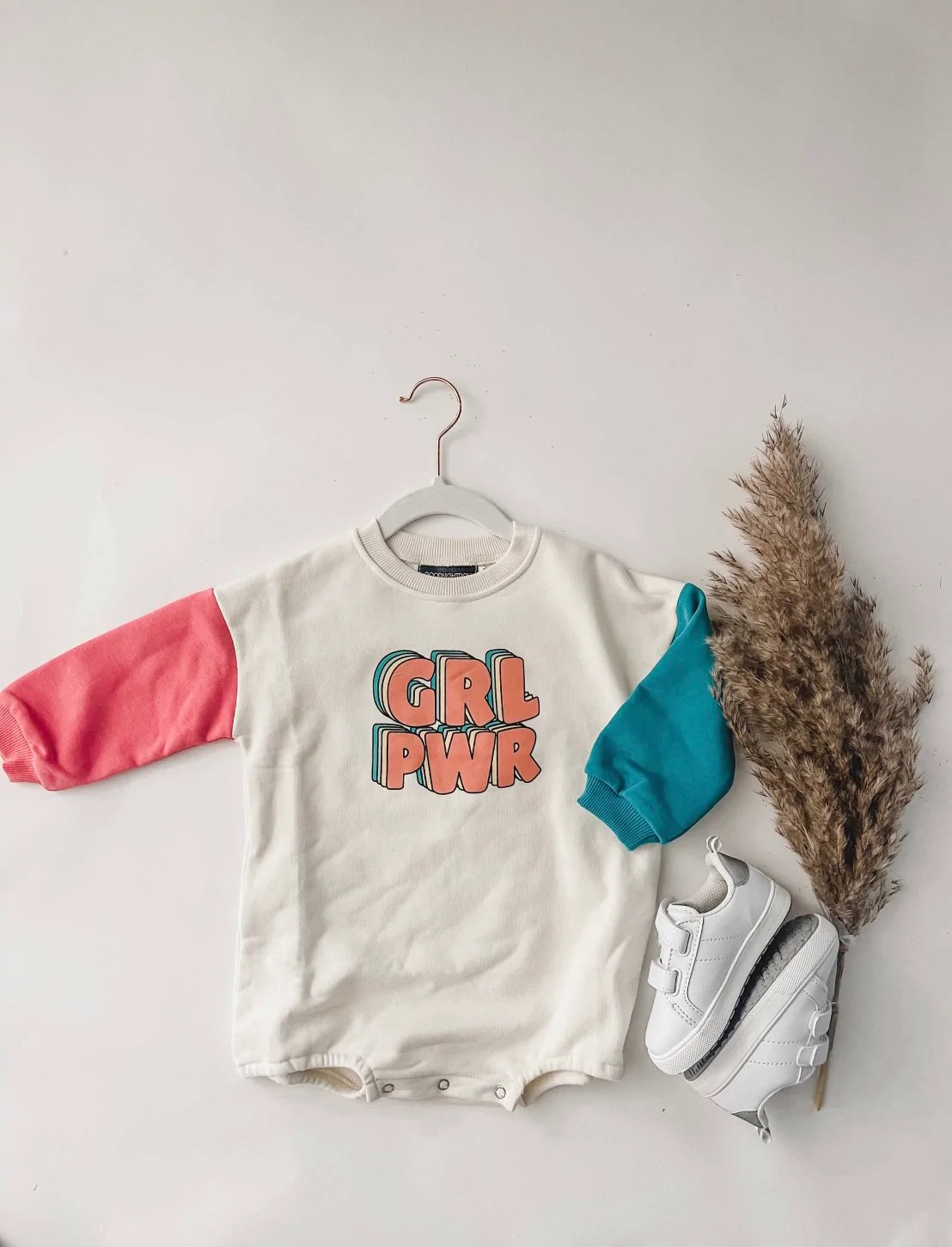 GRL PWR sweatshirt romper on a hanger