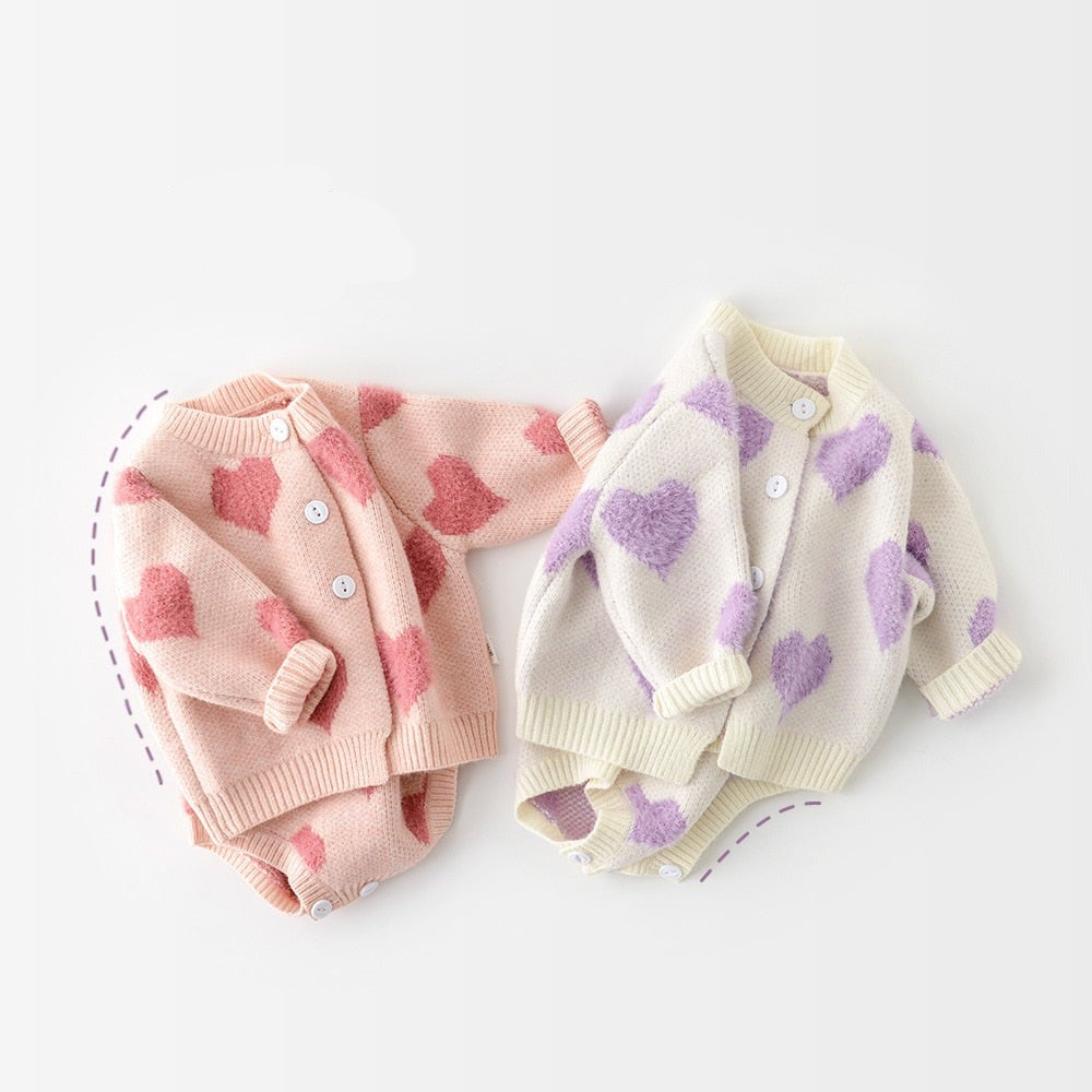 Pink and purple heart knit cardigans laid flat