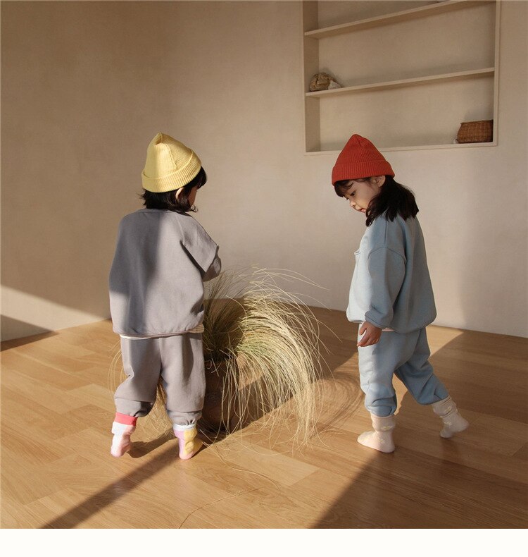 Kids in gray and blue sets, back view