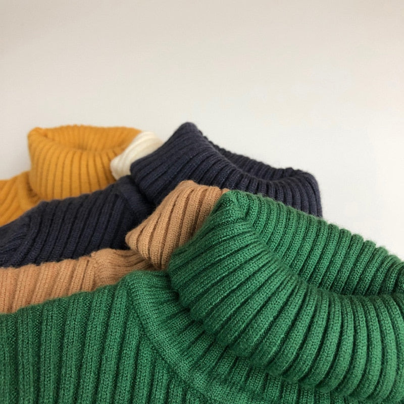 Close-up of turtleneck collars on kids knit sweaters