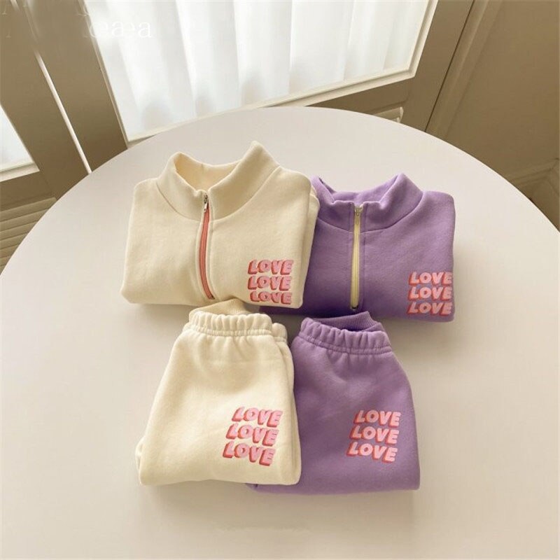 Beige and purple LOVE fleece sets laid flat