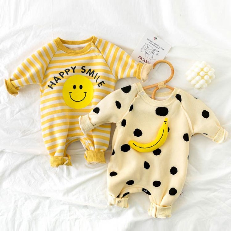 Happy Smile and banana rompers laid flat