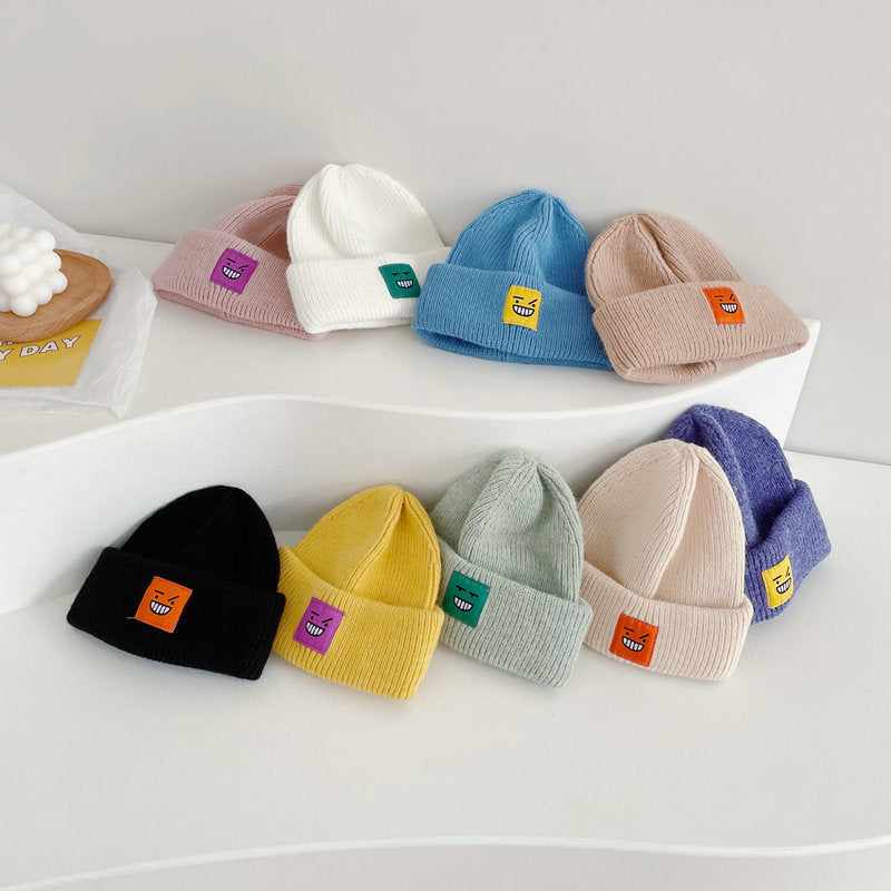 Smiley face patch knit beanies in many colours