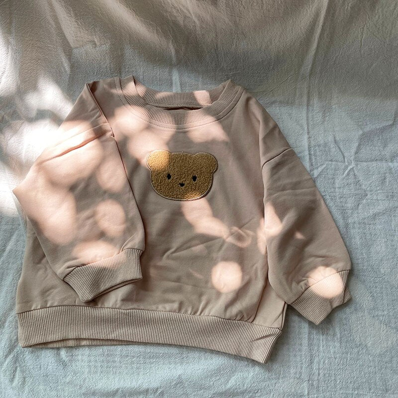 Taupe bear sweatshirt in dappled light