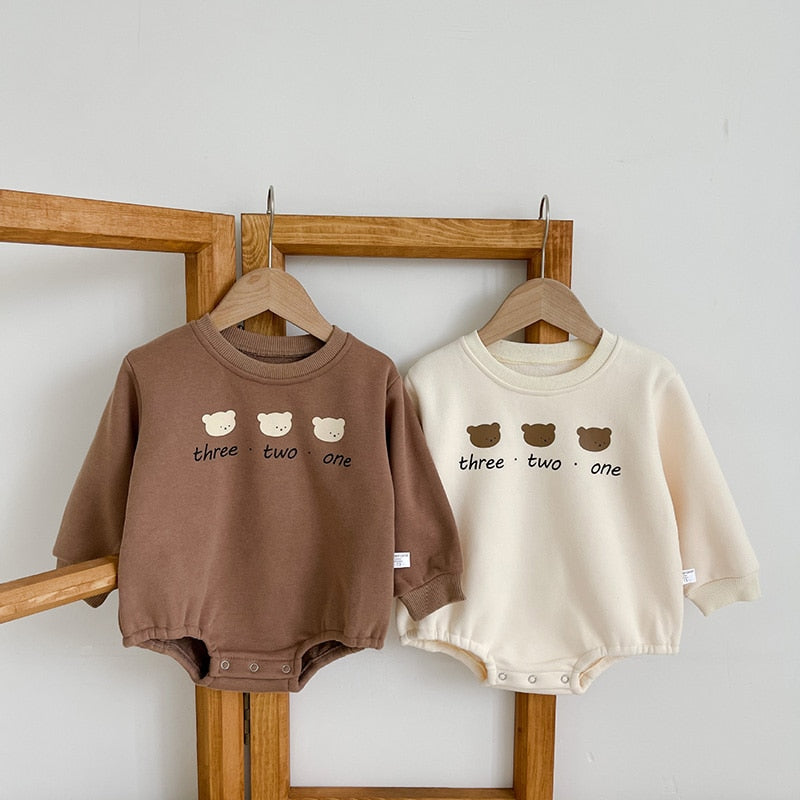 Brown and beige three bears rompers on hangers