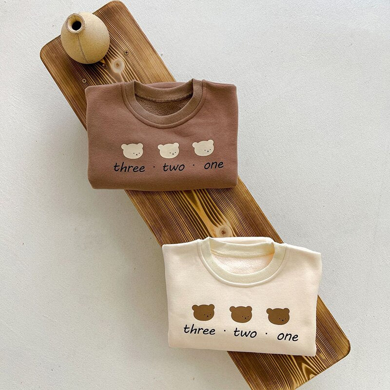 Three bears rompers on a wooden board