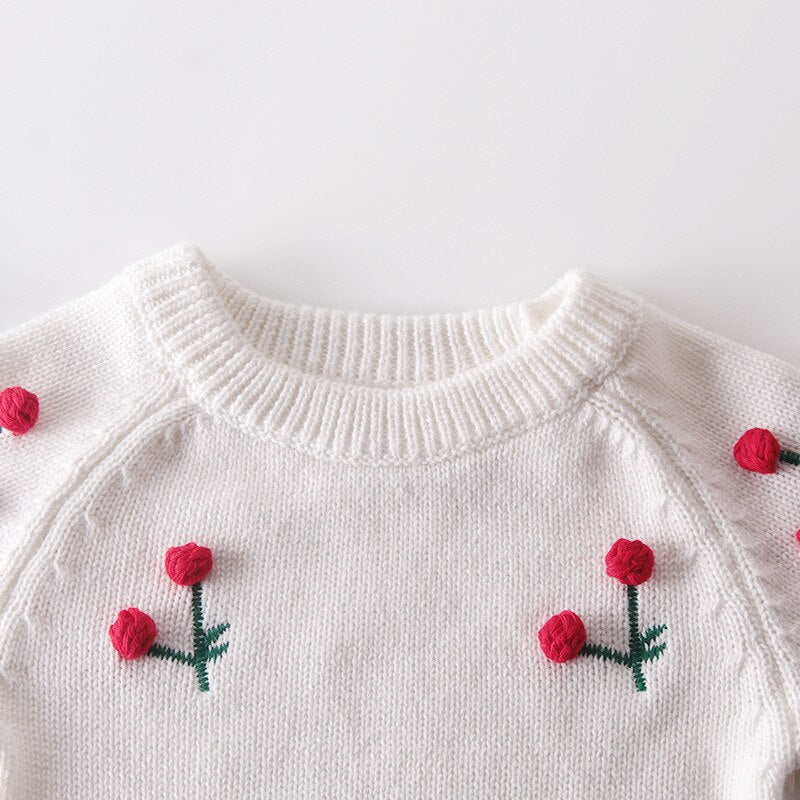 Close-up of cherries on white knit bodysuit