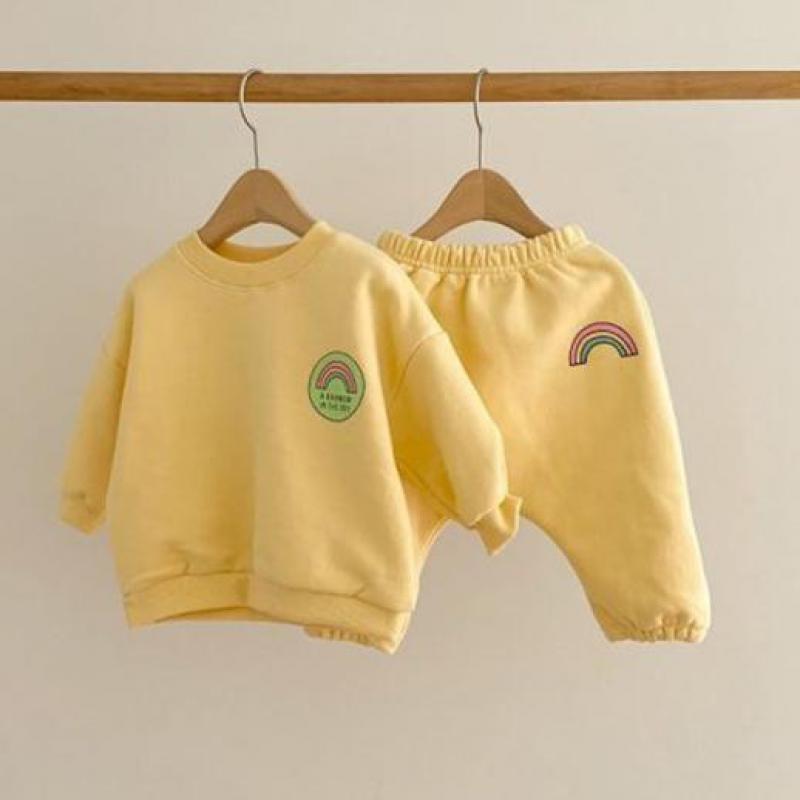 Yellow rainbow sweatshirt and pants on hangers